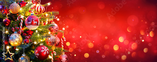Fotomural Christmas Tree With Ornament And Bokeh Lights In Red Background