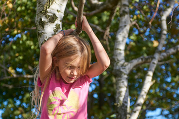 Wall Mural - Child brave cute girl climbing on tree