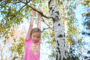 Wall Mural - Child brave cute girl climbing on tree