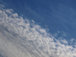 Summer background with white flying clouds on blue sky. Romantic natural heaven backdrop. 