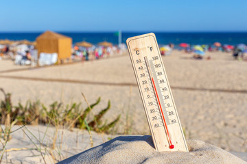 Thermometer for the temperature on the beach, in the summer in the heat. Global warming.