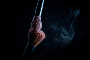 Makeup brush with pink on the black background