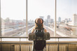 Traveler Rear view woman standing at the window in hall Train Station departure with backpack , Selective focus, Travel concept. transportation concept. Theme travel public transport