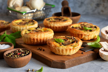 Wall Mural - Puff pastry cake with mushrooms on a concrete background.