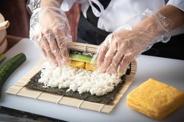 Poster - sushi chef making roll sushi with cucumber and egg