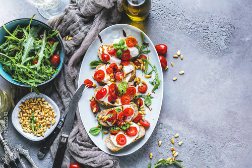 Fotomural Italian bruschetta with chopped tomatoes, basil and mozzarella on grilled crusty