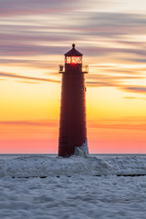 Wall Mural - lighthouse with ice at sunset