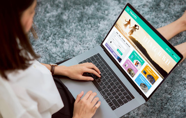 Wall Mural - woman sitting in her house with using laptop and booking flight travel search ticket holiday and hotel on website discounted price, concept technology online marketing and promotion.