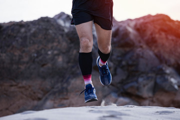 Wall Mural - Young fitness man trail runner at mountain ,Man jogging through landscape mountains background,Trail runners concept