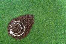 Brown Arbica Coffee Beans In White Coffee Mug On Green Gress Background.