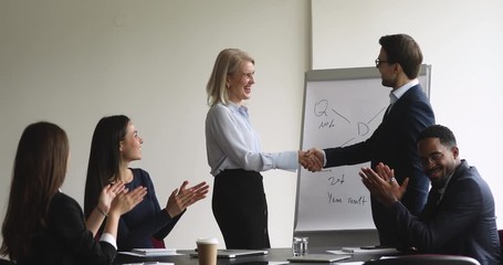 Canvas Print - Male manager handshaking older executive conference speaker get team applause