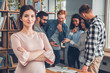 © Viktoriia - Startupers working together at office pregnant woman close-up crossed arms looking camera serious while colleagues using digital tablet