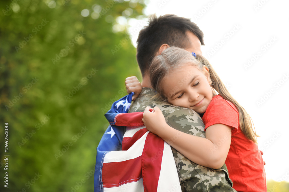 Father in military uniform with American flag hugging his little daughter at green park - obrazy, fototapety, plakaty 