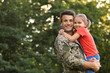 © New Africa - Father in military uniform holding his little daughter at green park
