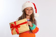 © New Africa - Happy little child in Santa hat with gift box on light grey background. Christmas celebration
