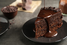 Pouring Chocolate Sauce Onto Delicious Fresh Cake On Grey Table, Closeup