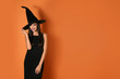 © New Africa - Beautiful woman wearing witch costume for Halloween party on yellow background, space for text