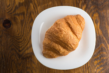 two croissants on a white plate on a white background