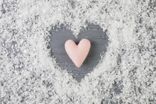 Pink Heart Between Decorative Snow On Wooden Desk