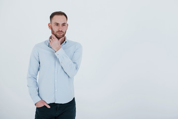 Wall Mural - One person. Man in official clothes stands against white background in the studio