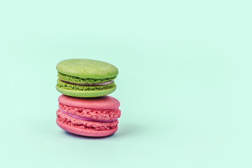 Assorted colorful macaroons on mint green background with copy space.