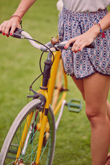 Wall Mural - Pretty woman standing with old bicycle outdoors.