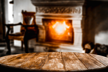 Table top with blurred fireplace and cosy home interior background.