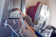 © astrosystem - Woman using cellphone in modern airplane seat.