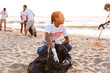 © Drobot Dean - Image of volunteers worker cleaning beach from plastic with trash bags