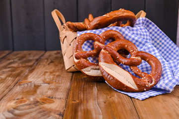 Bavarian pretzel decorated with a blue and white cloth on a rustic wooden board - Munich Oktoberfest. 