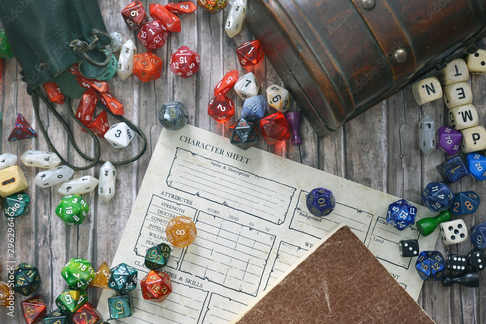 Tabletop roleplaying flat lay with colorful RPG and game dices,  character sheet, rule book and treasure chest on wooden desk - obrazy, fototapety, plakaty 