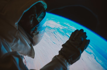 Wall Mural - astronaut looking planet earth from the window of his capsule. concept about science and space explo