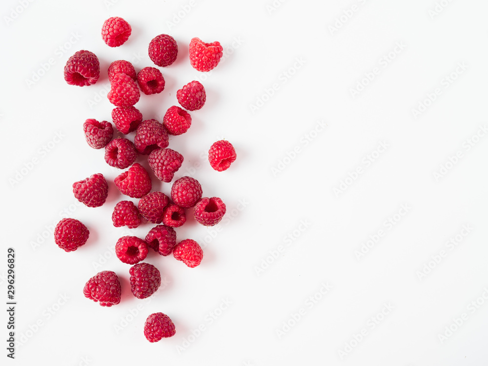 Heap of fresh ripe red raspberries on white background. Raspberry with copy space for text or design. Top view or flat lay. - obrazy, fototapety, plakaty 
