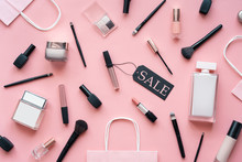 Cosmetic And Perfume Female Products Accessories Promotion Offer With Sale Tag Beauty Makeup Fashion Items Objects Set With Shopping Bags On Pink Table Background, Flat Lay, Top View Above
