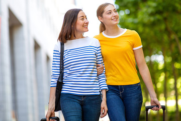 Wall Mural - smiling mother and daughter walking outdoors with bags