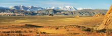 Typical Landscapes Of Mongolia. Snow On The Peaks, Desert Mountain Slopes And Valleys.