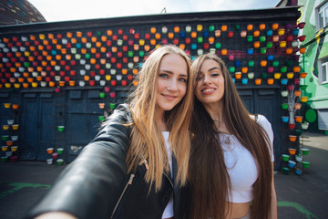 two very cute young girls posing as top models on a street in Europe on vacation,sisters actively posing on a sunny summer day ,very happy and joyful people