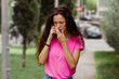 © Clara - Worried woman on the street after hearing a bad new on the phone. Breast cancer awareness month