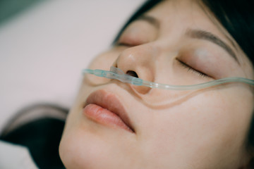 nasal cannula deliver oxygen for patient suffering respiratory disease. closed up view of sick asian