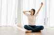 © whyframeshot - happiness beauty asian woman enjoy song music with headphone full body on wooden laminate floor in living room