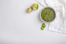 Tomatillo Salsa Verde. Bowl Of Spicy Green Sauce On White Table, Mexican Cuisine. Top View. Copy Space.