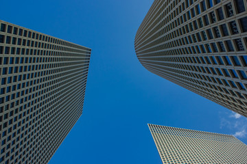 Wall Mural - modern city skyscraper high building perspective urban photography from below on blue sky background 