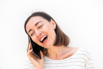 Wall Mural - happy middle aged woman talking with mobile phone by white background