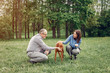 © hetmanstock2 - Couple in a forest. Adult pair with cute dogs. Lady in a blue shirt