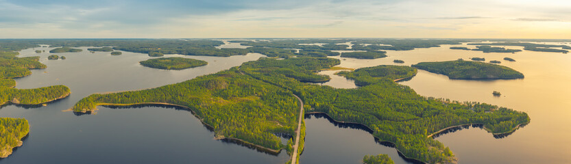 Poster - Aerial view of road between green summer forest and blue lake in Finland