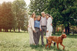 © hetmanstock2 - Family in a summer park. People walking with a dog. Parents with a two daughters