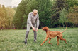 © hetmanstock2 - Hundsome man in a park. Adult male with cute dog