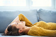 © Bartek Szewczyk/Westend61 - Cheerful young woman lying on sofa with eyes closed and relaxing