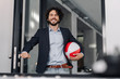 © KNSY/Westend61 - Happy businessman holding beach ball in office