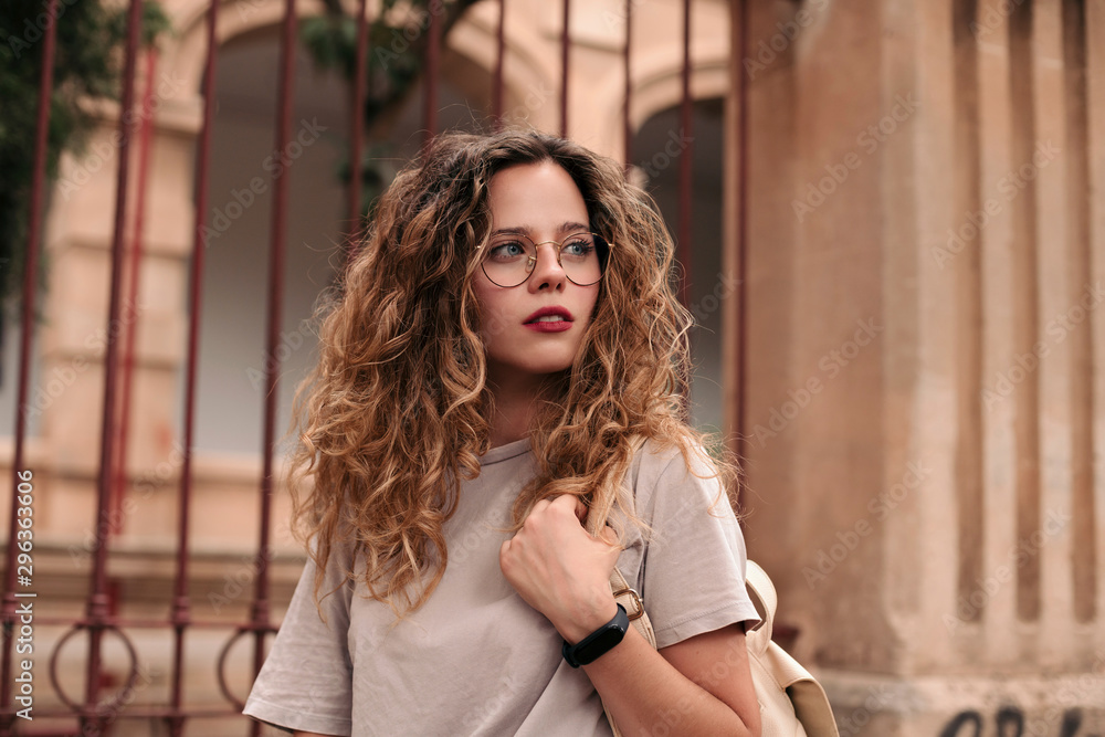 Beautiful young woman with curly hair and glasses in the city Stock ...